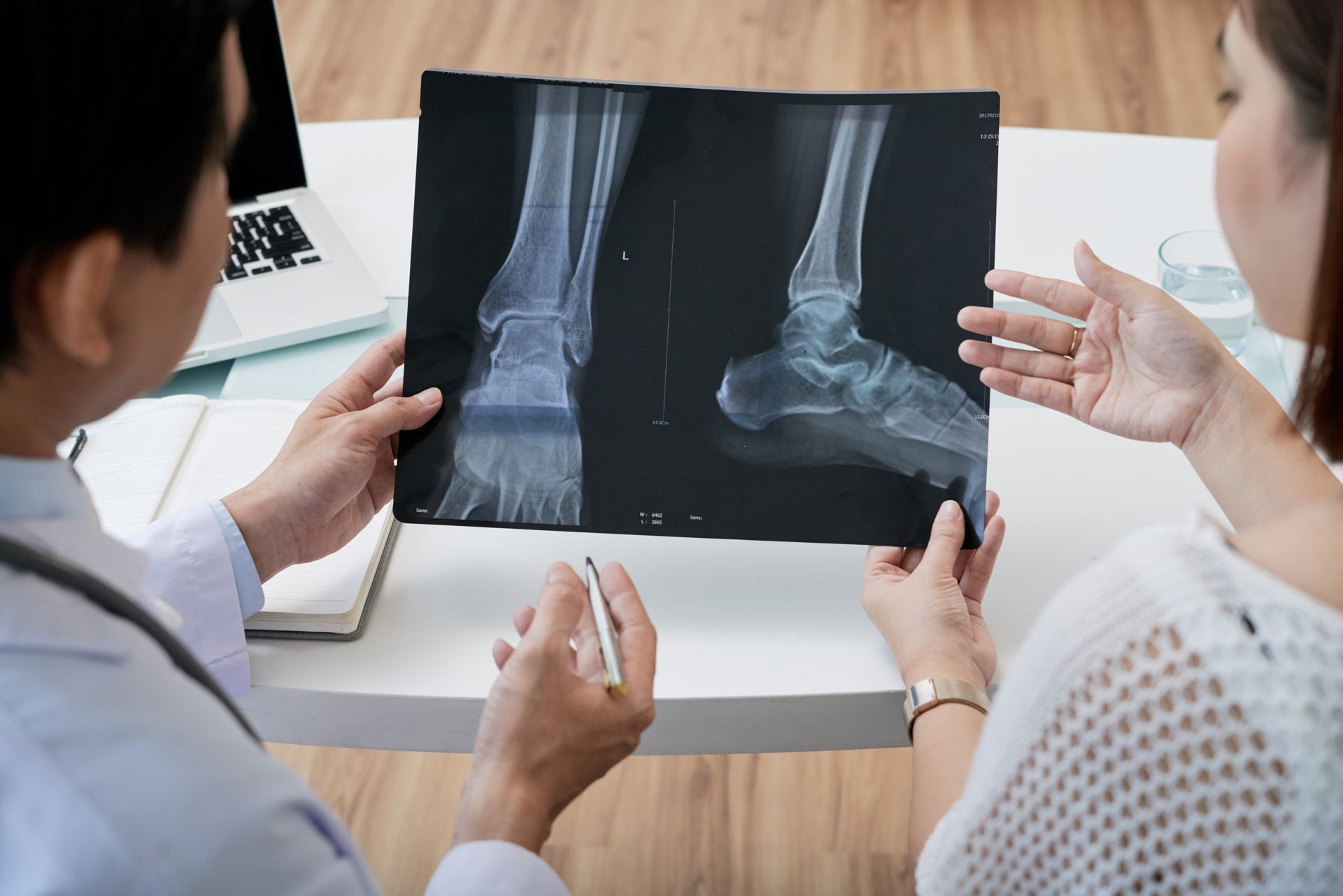 A doctor is showing a woman an x-ray of her ankle.