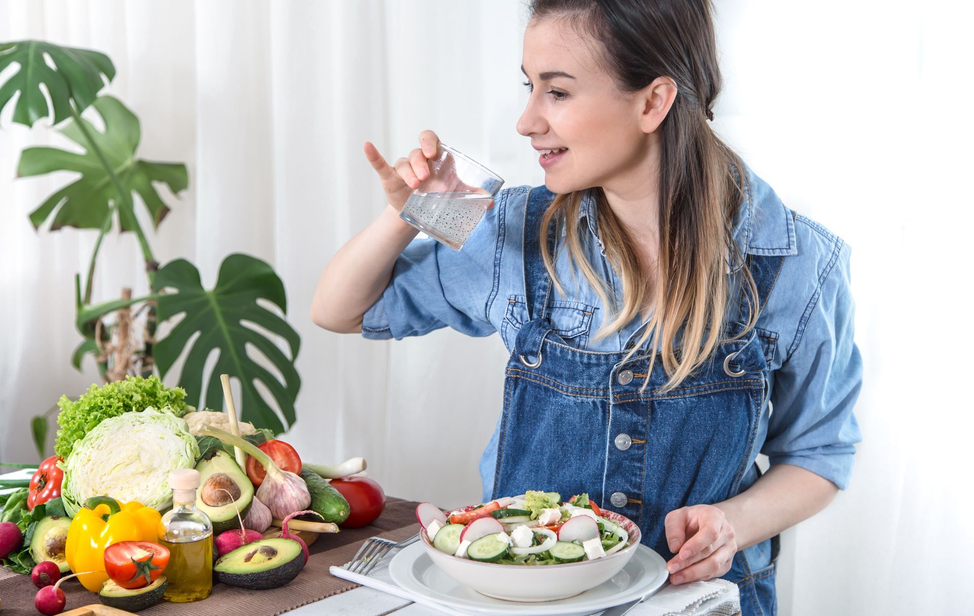 A woman is sitting at a table eating a salad.