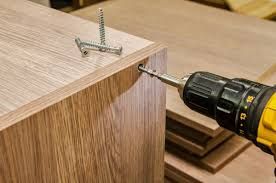 Person sanding a wooden floorboard with an electric sander, indoors. Person sanding a wooden floorboard with an electric sander, indoors.
