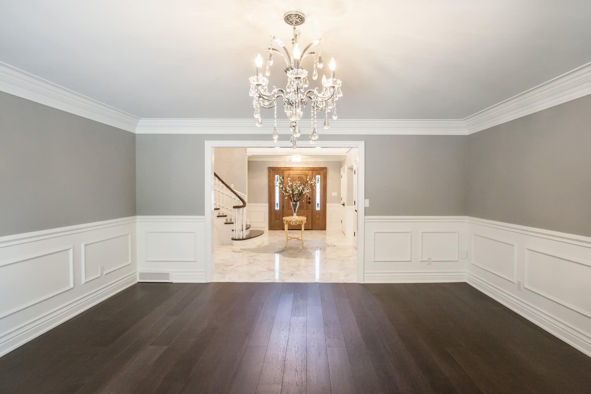 A carpenter works on installing white kitchen cabinets in a room with a window. A carpenter works on installing white kitchen cabinets in a room with a window.