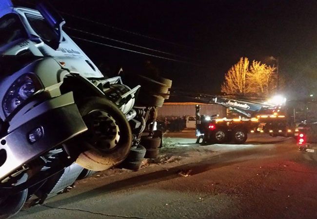 A tow truck using a winch on an overturned semi A tow truck using a winch on an overturned semi