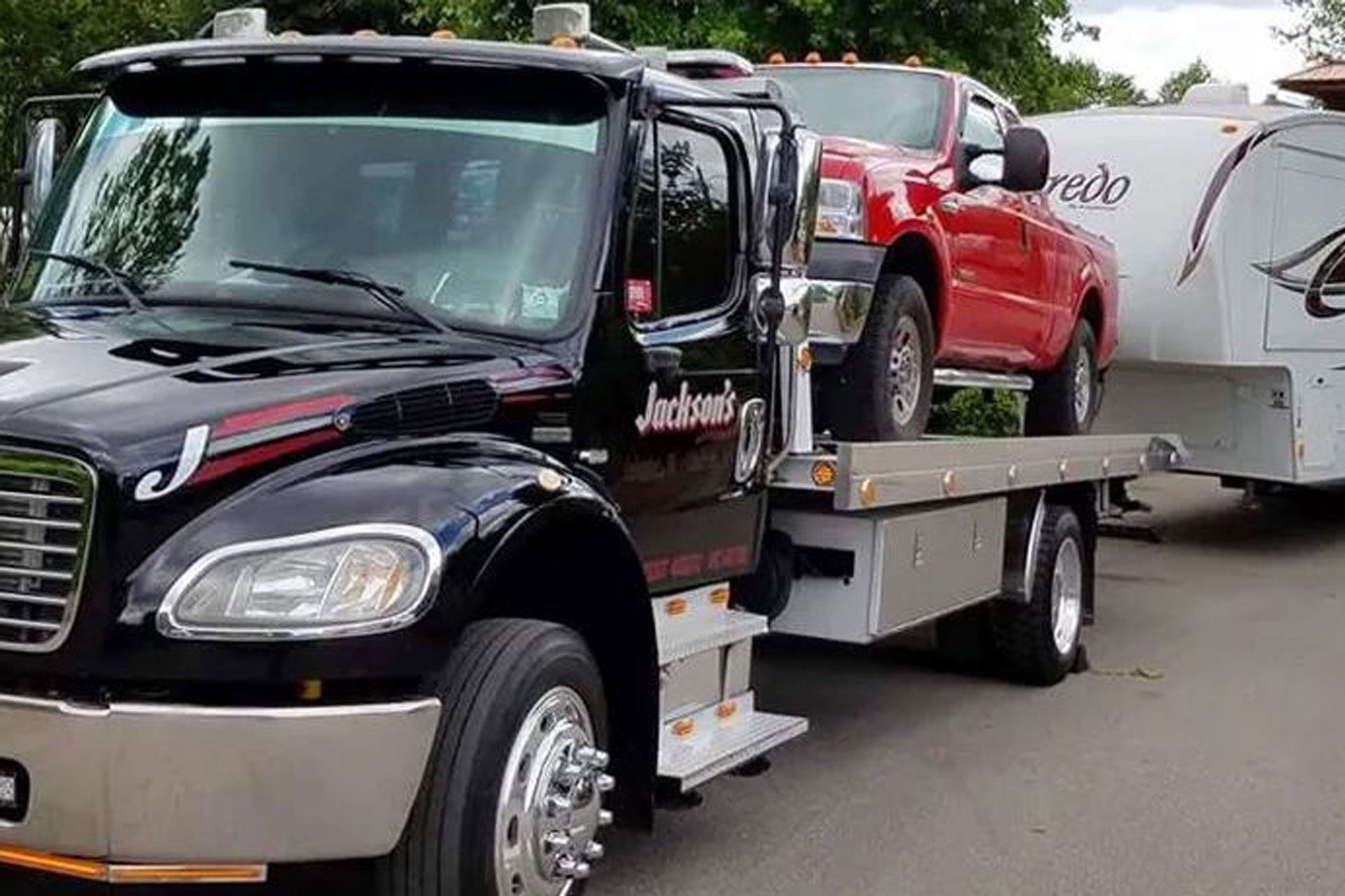 A flatbed wrecker carrying a pickup truck A flatbed wrecker carrying a pickup truck