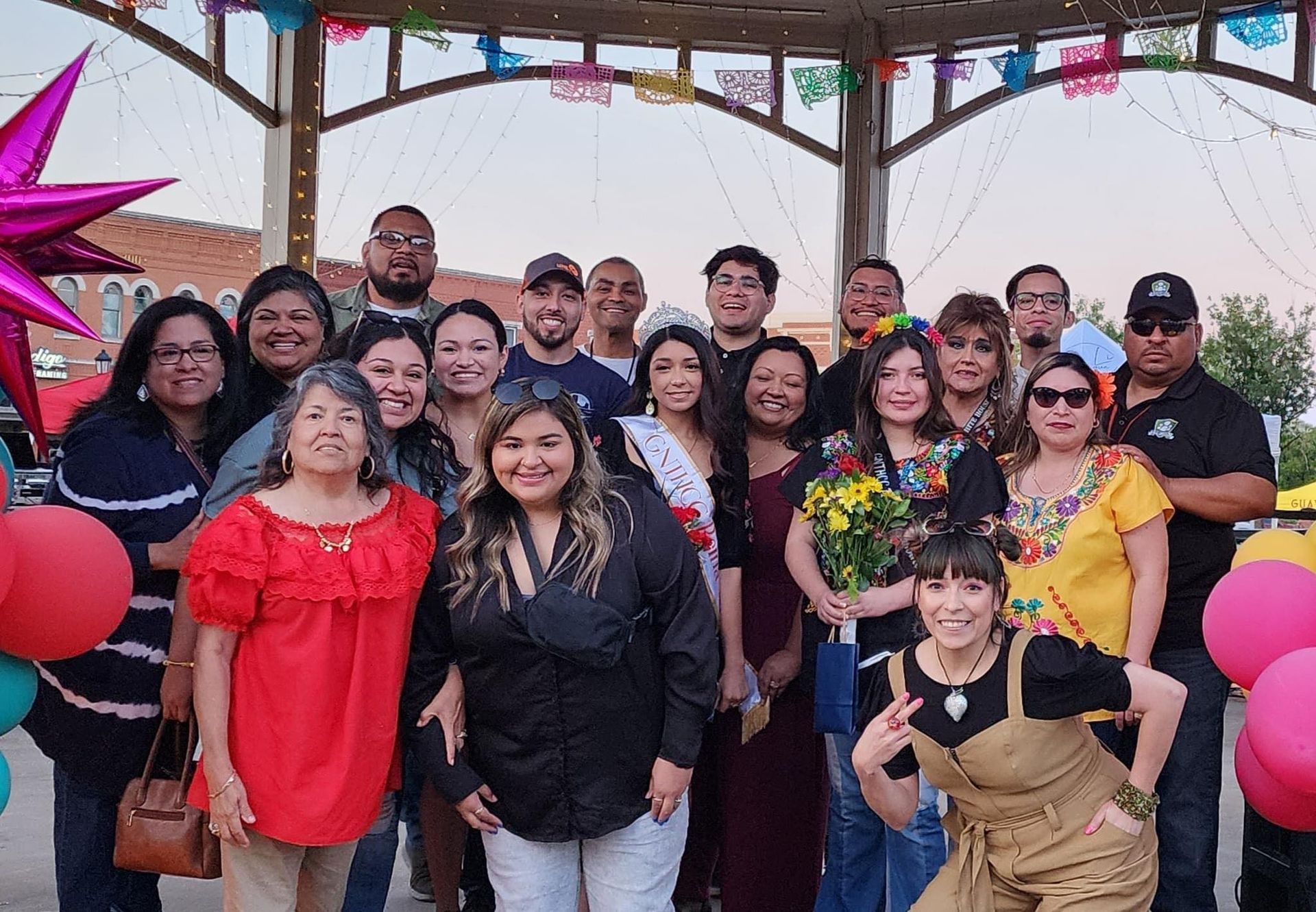 A group of people are posing for a picture in front of a gazebo.