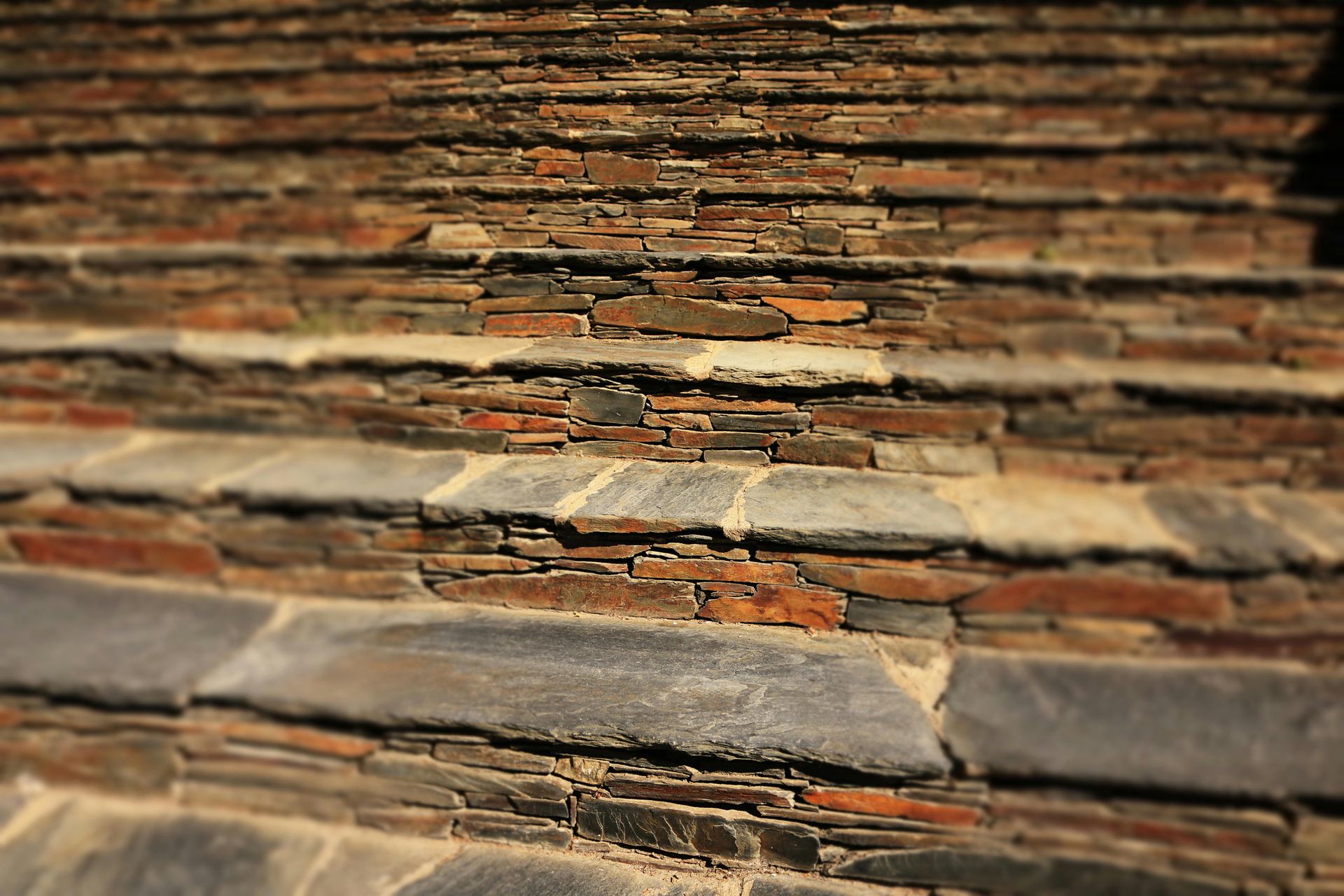 A set of stone steps leading up to a stone wall.