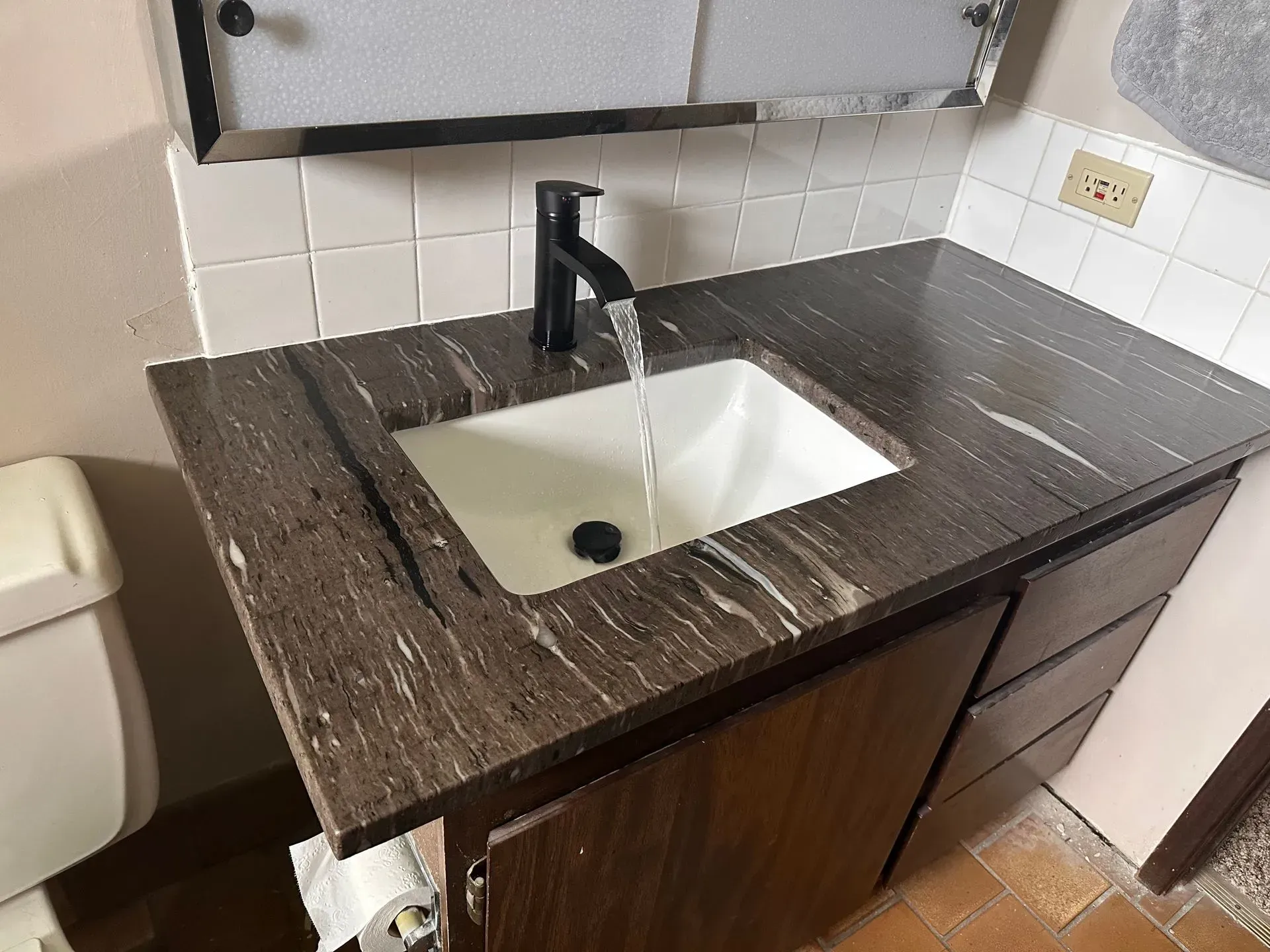 Construction site with underground pipes in trench, buildings in the background.