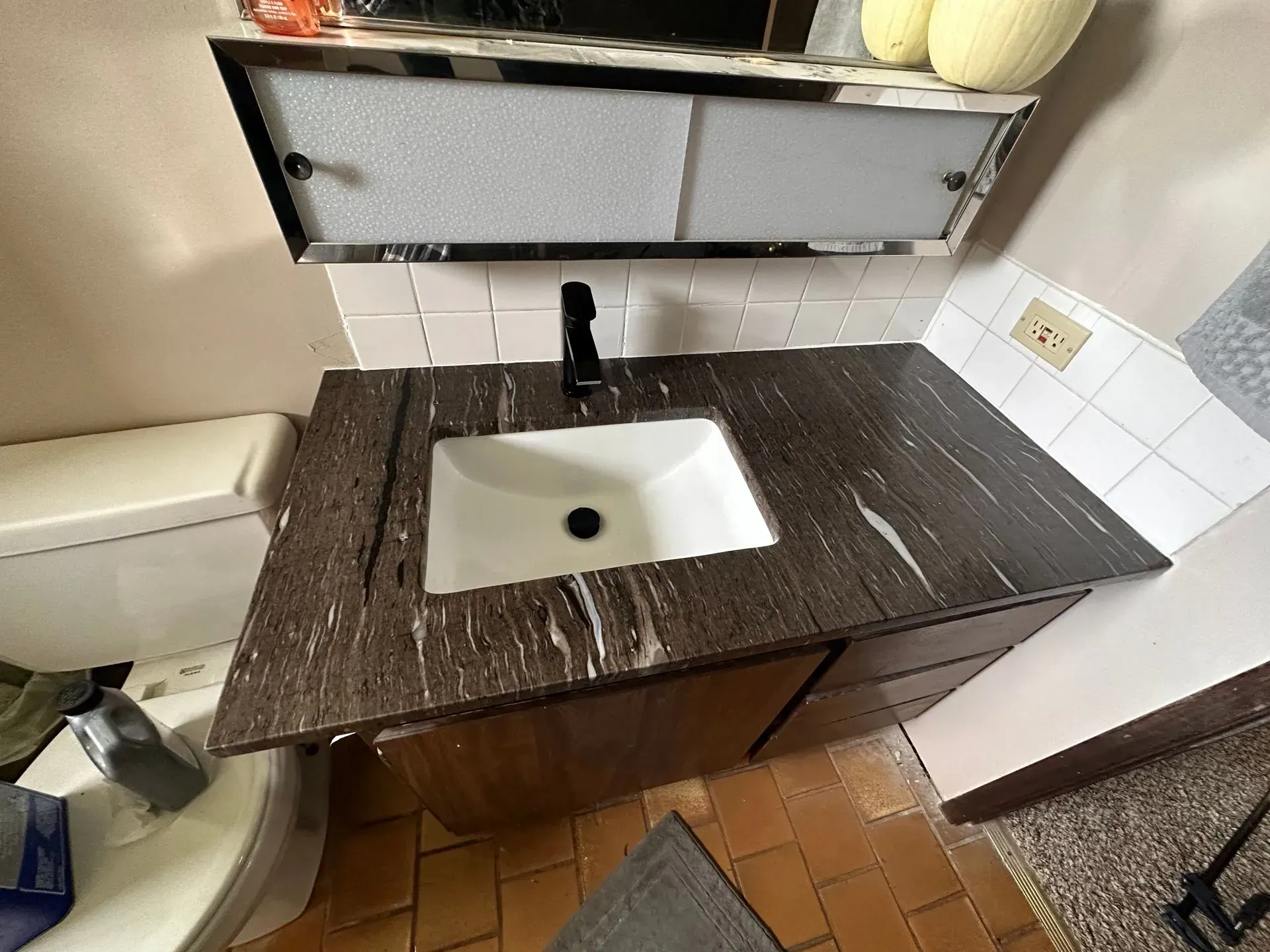 Bathroom with a dark granite countertop, white sink, and black faucet.