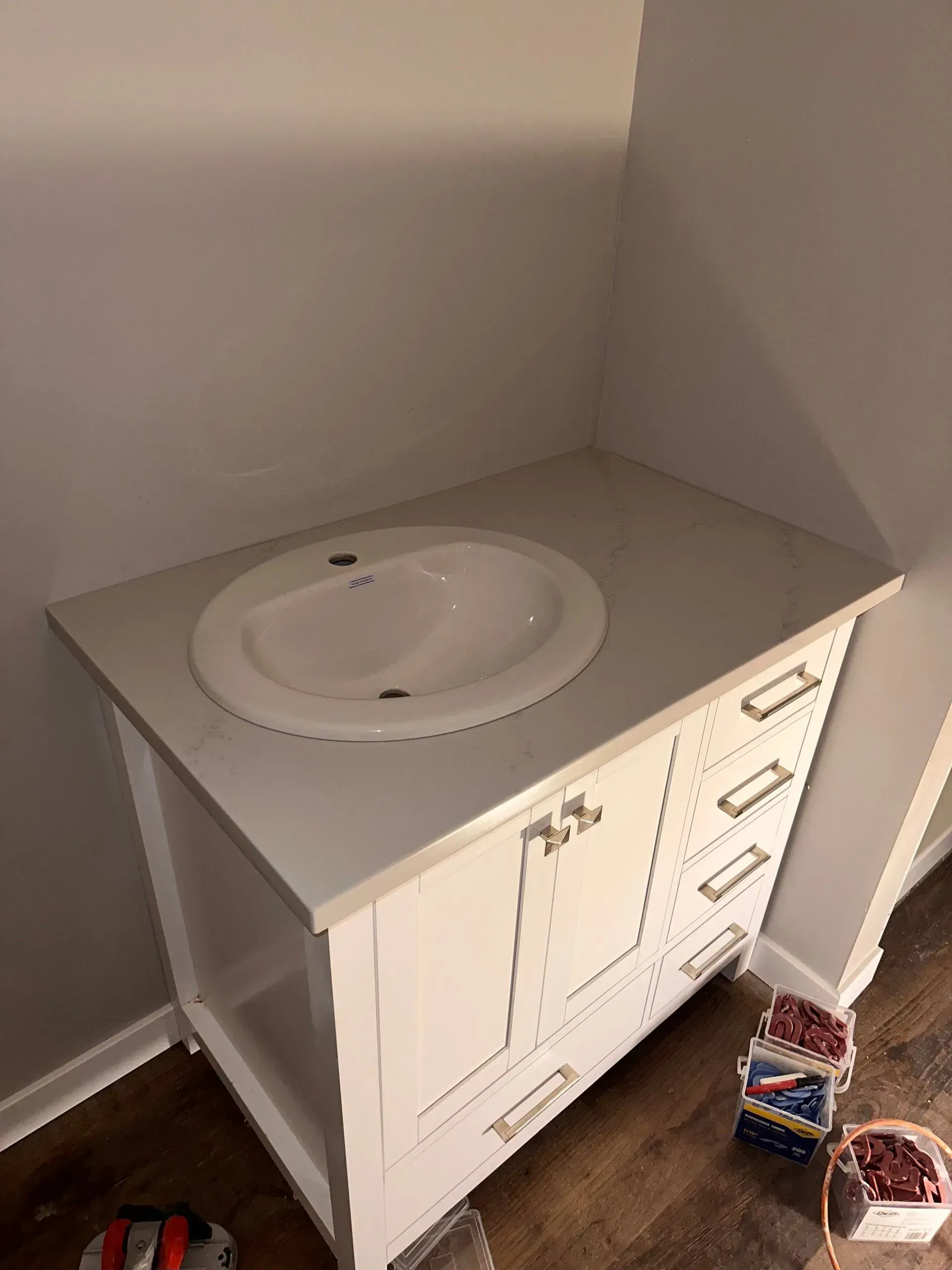 Two men are standing in an empty room with black walls