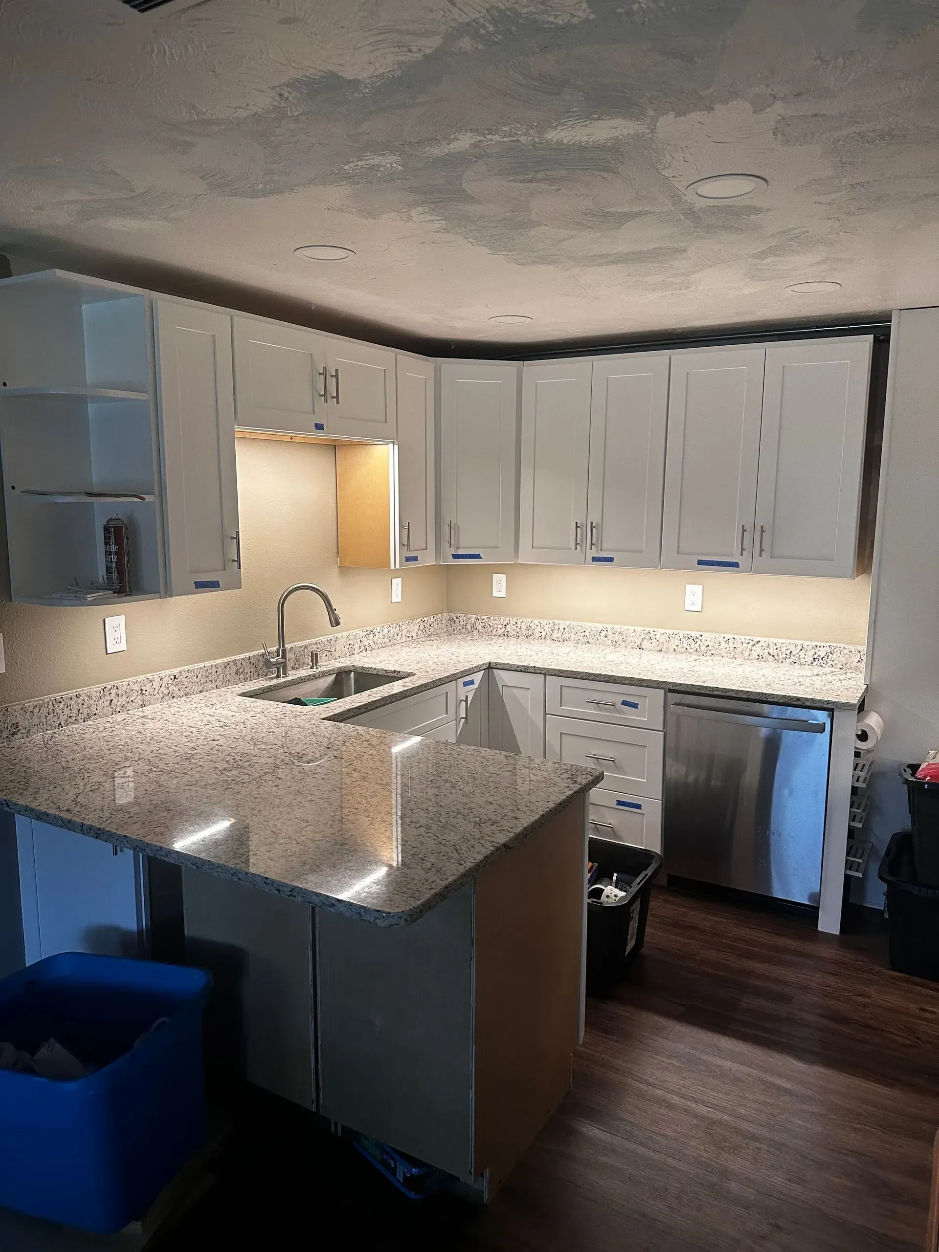 Renovated kitchen with white cabinets, granite countertops, and stainless steel appliances.