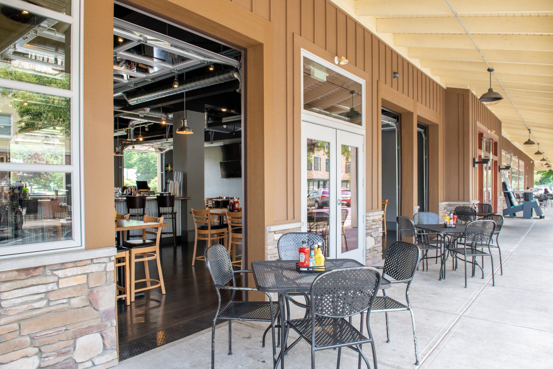 A restaurant with tables and chairs outside of it.