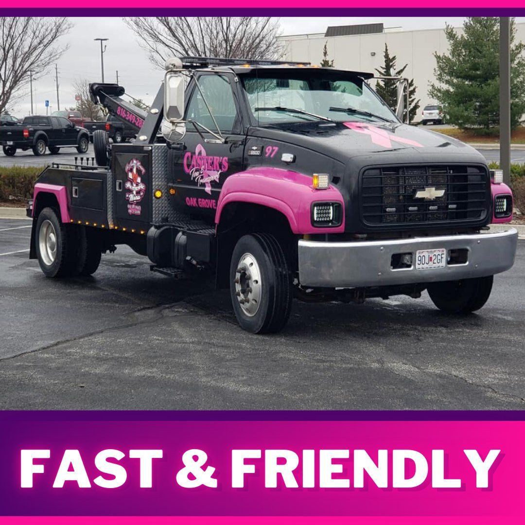 Pink and black tow truck in a parking lot, advertising fast and friendly service.