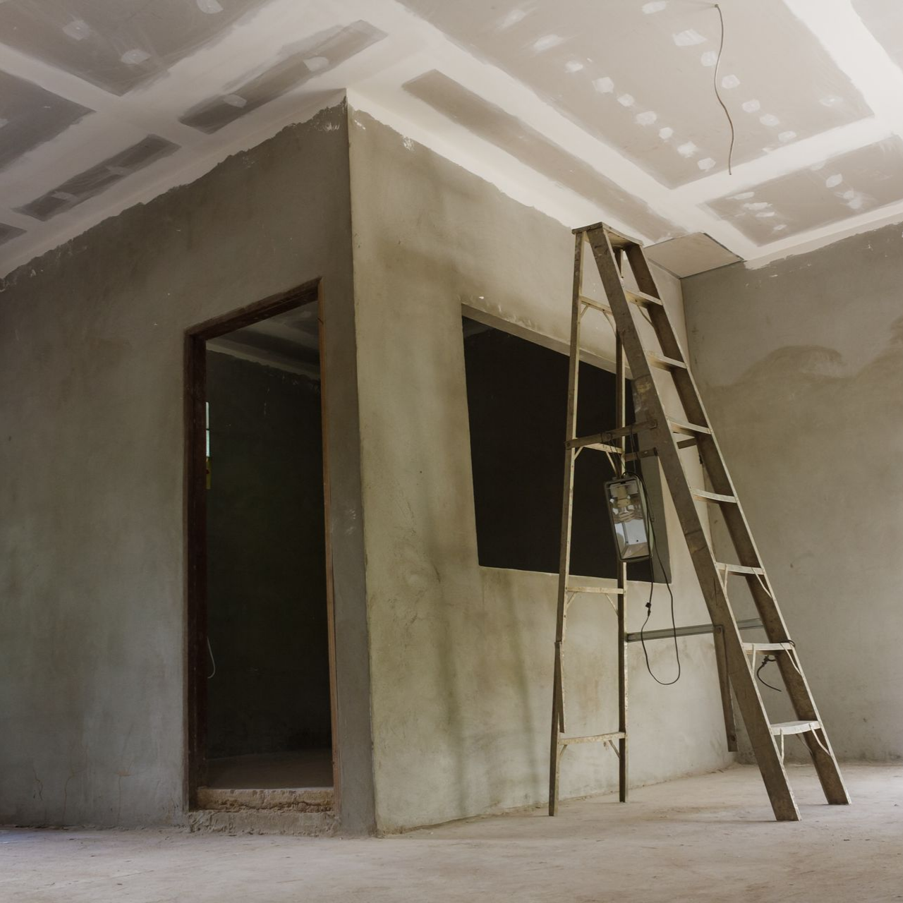 Room under construction with ladder, window, and doorway; gray walls, white ceiling.