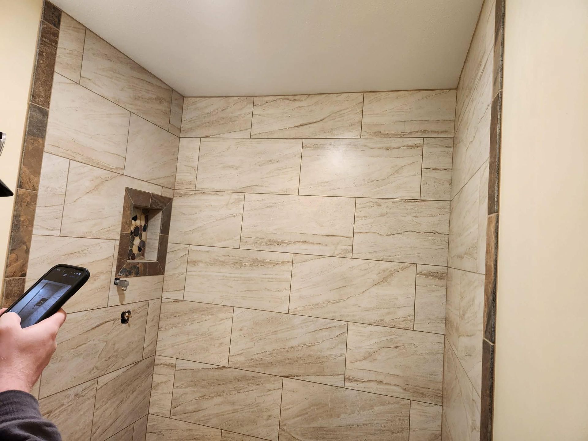 Kitchen renovation in progress, dark blue cabinets installed, island frame in foreground, windows with outdoor view.