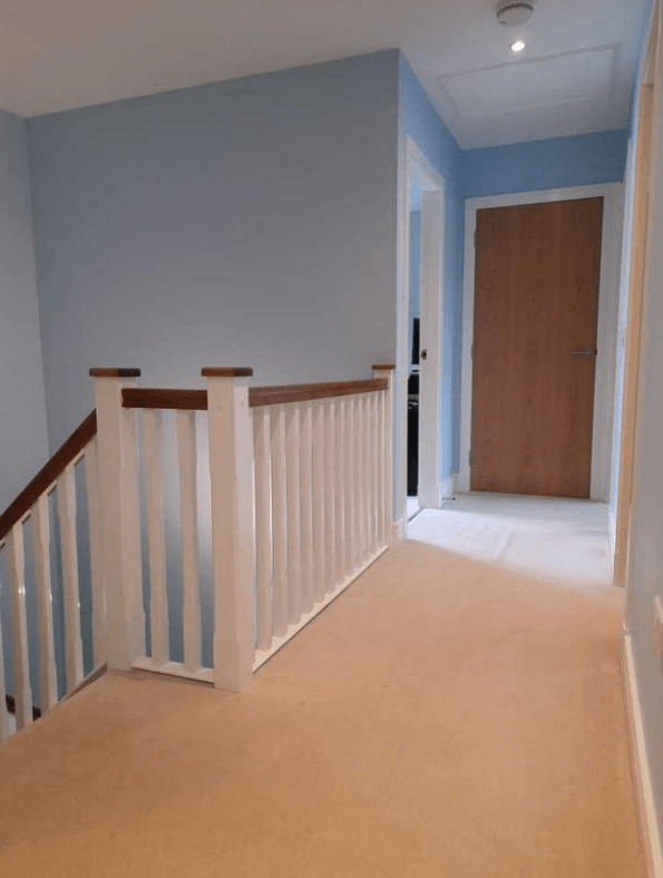 Picture of a landing and stairs in baby blue and white by painters and decorators London
