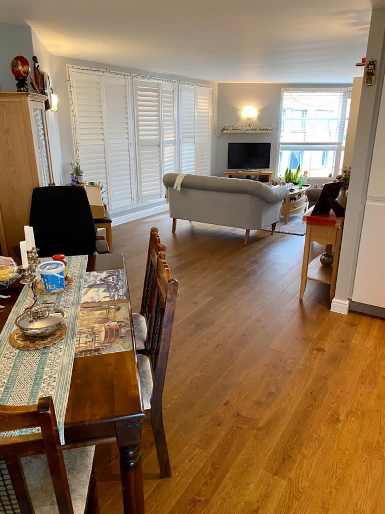 Picture of an open plan apartment living and dining space decorated in grey by painters and decorators London