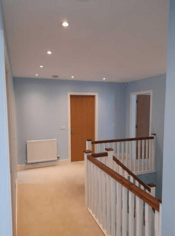 Picture of a landing and stairs in baby blue and white by painters and decorators London