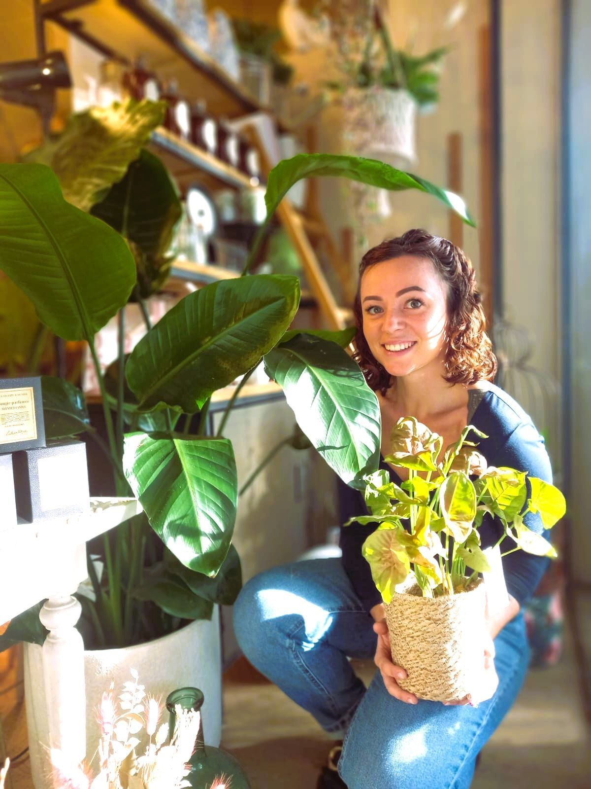 Une femme se cache derrière un bouquet de fleurs blanches.