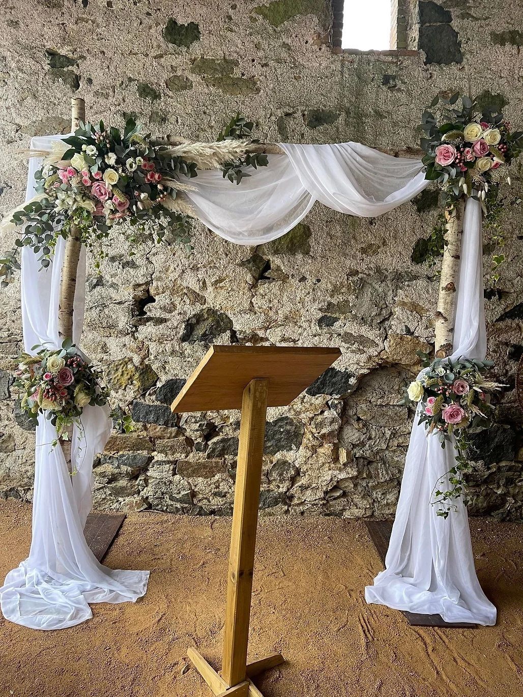 Un podium en bois est posé devant un mur de pierre.