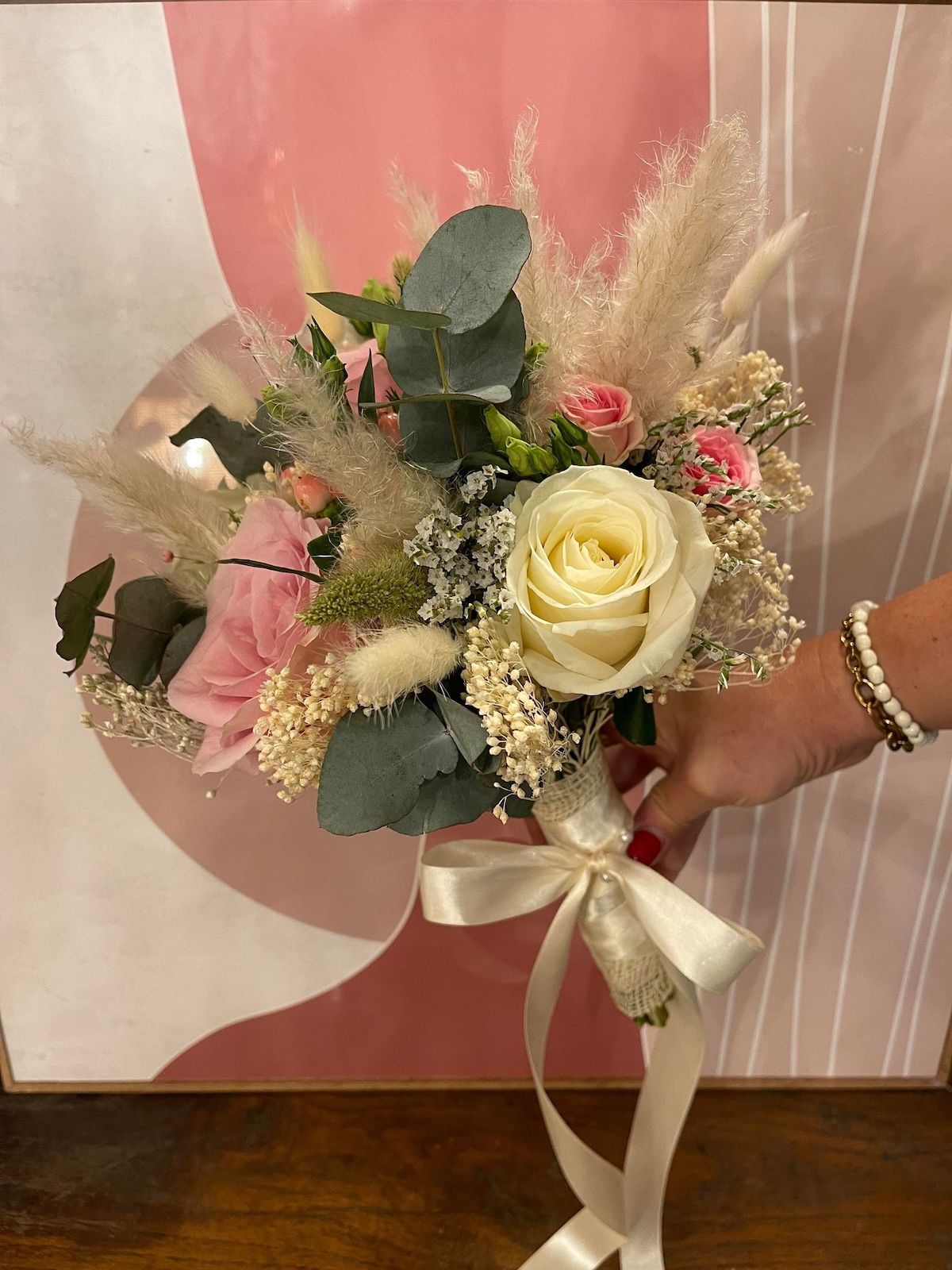 Une personne tient un bouquet de fleurs dans sa main.