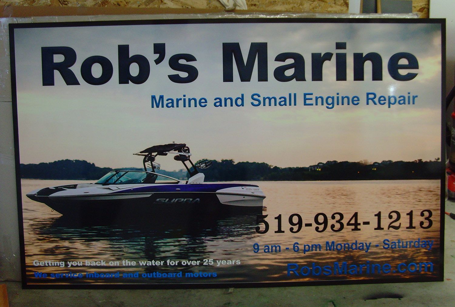Sign for Rob's Marine, offering marine and small engine repair. Features a boat on water and a phone number.
