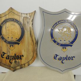 Two wooden shield plaques; one natural wood, one silver, both with 