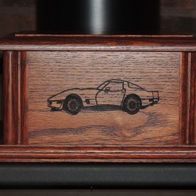 Wooden box with an engraved drawing of a classic car on the front.