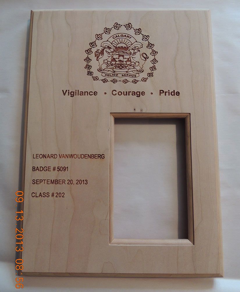Wooden plaque with engraved emblem, text: 