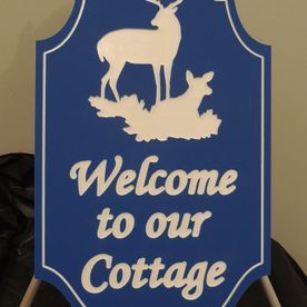 Blue cottage sign with white deer silhouette and 