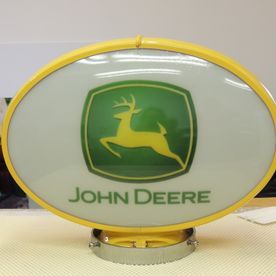 John Deere illuminated sign with a green and yellow logo on an oval background.