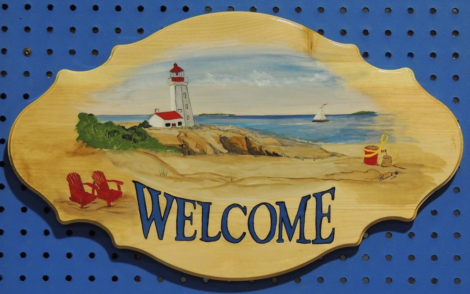 Wooden sign with a beach scene, lighthouse, and the word 