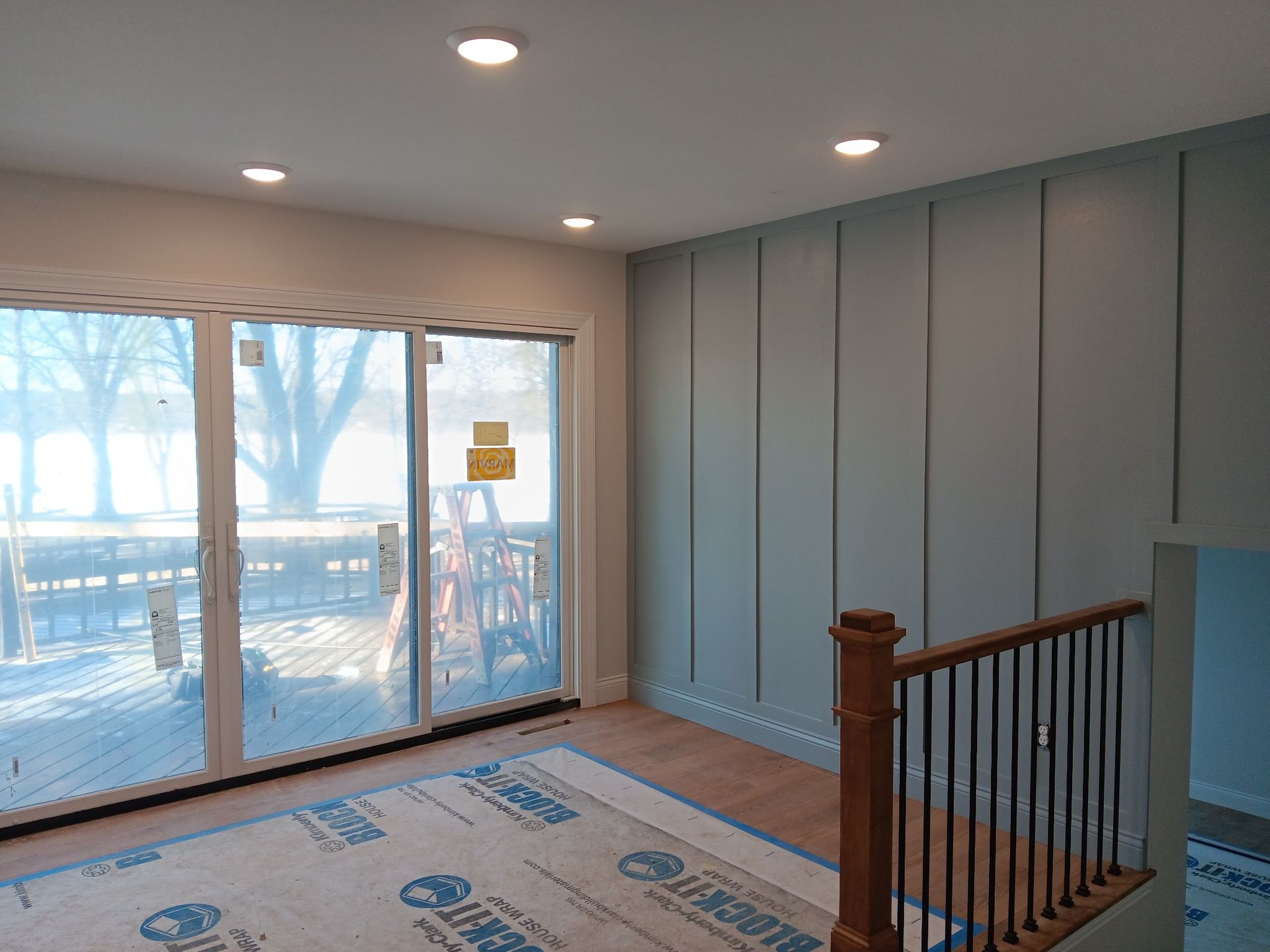 Living Room with Sliding Glass Doors and a Wooden Railing — St Cloud, MN — Fine Line Paint LLC