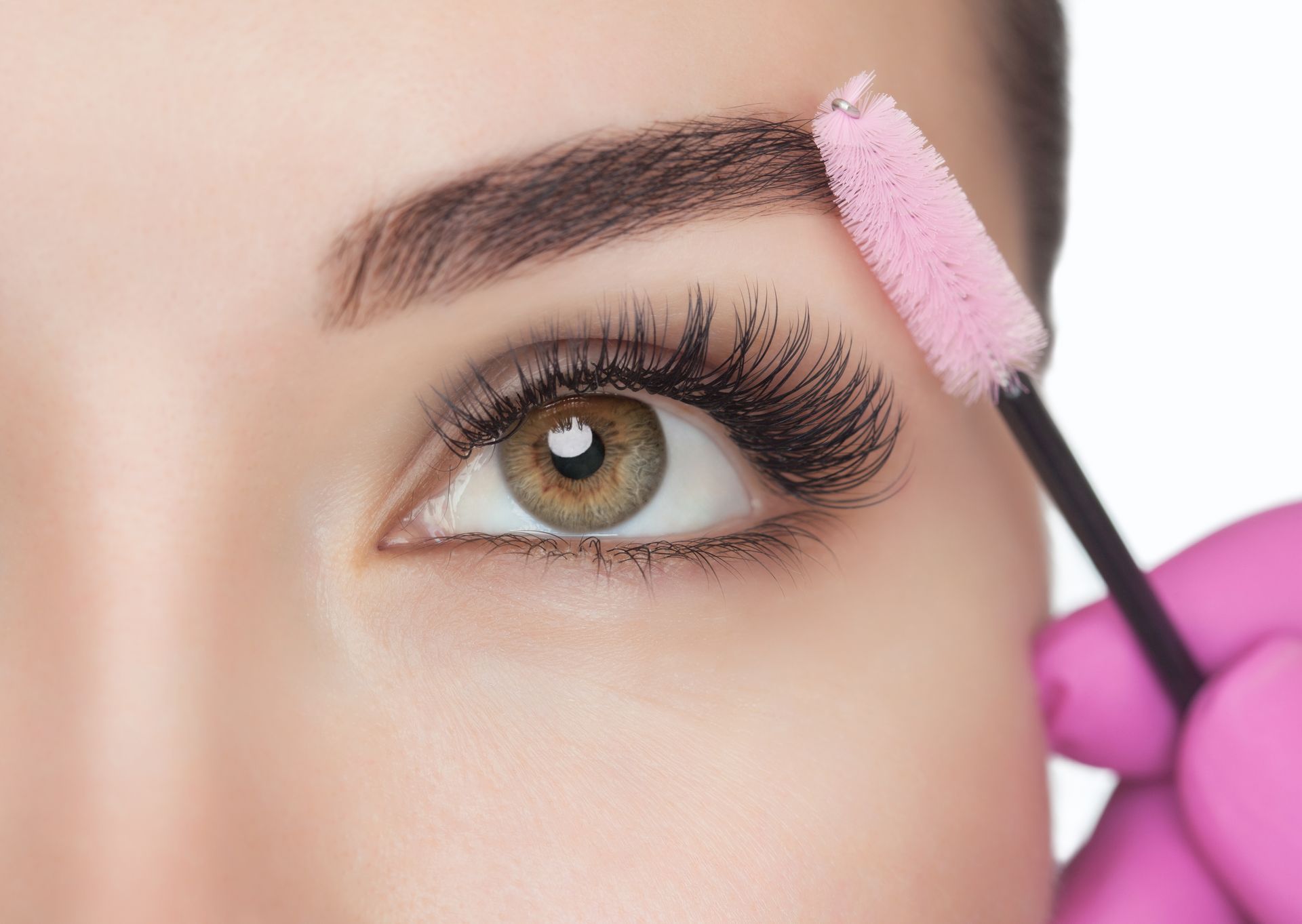 a woman 's eye is being brushed with a pink brush