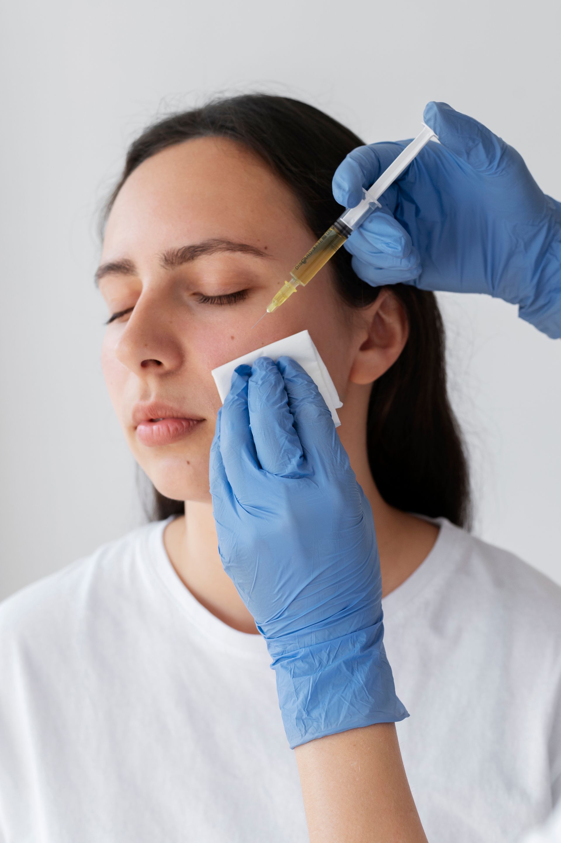 a woman getting an injection in her face with a syringe