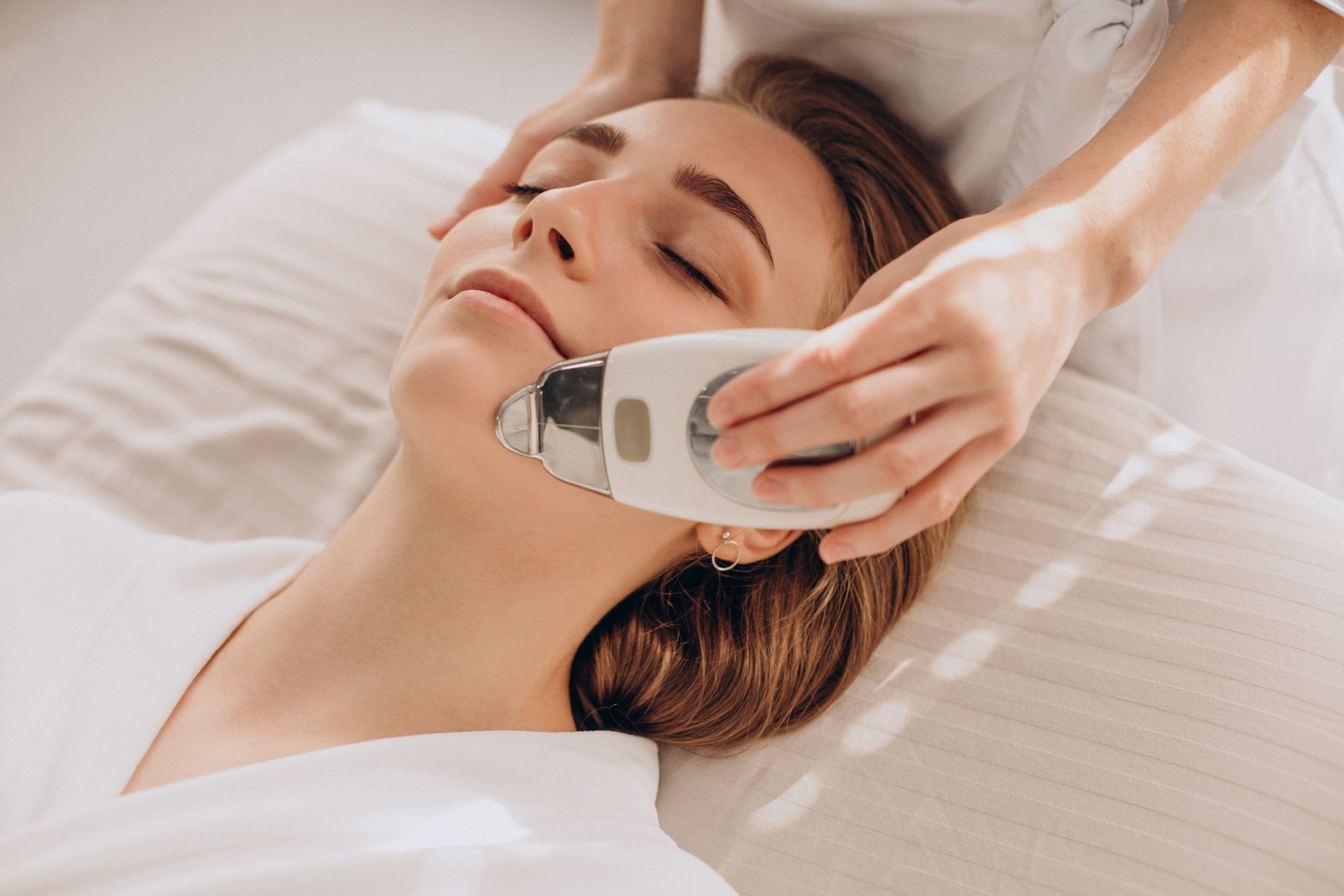 a woman laying on a bed getting a facial treatment