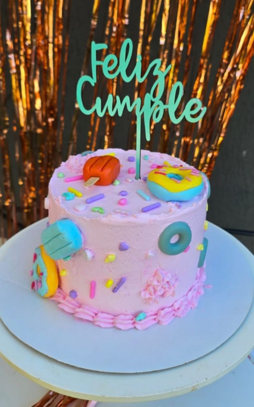 Un pastel rosa con un adorno que dice amor.