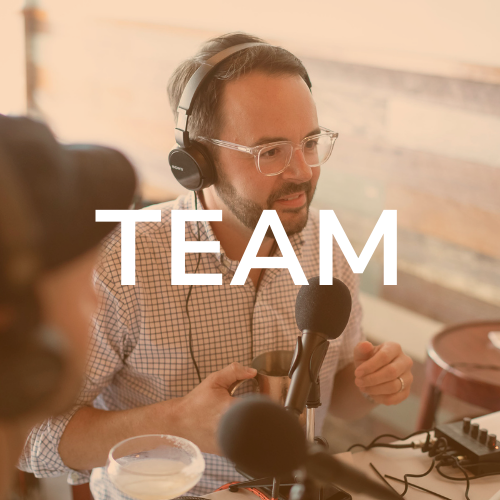 A man wearing headphones speaks into a microphone, recording. The word 