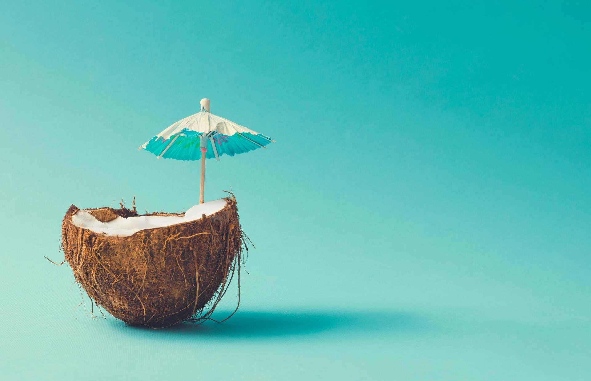 Coconut on a blue background with a umbrella on top