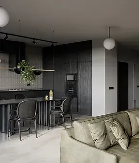 A living room with a couch , chairs , a table and a kitchen.