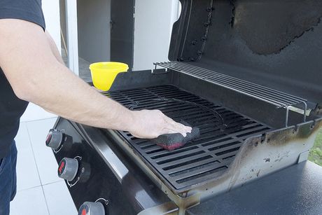 man cleaning the grill
