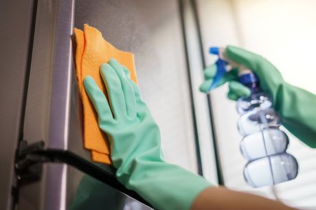 woman wiping a refrigerator