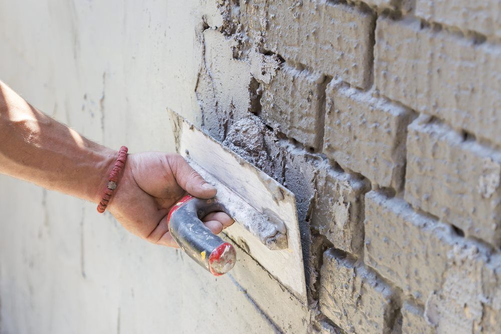 Men Plastering Stone Bricks — HJK Plastering in Lismore, NSW