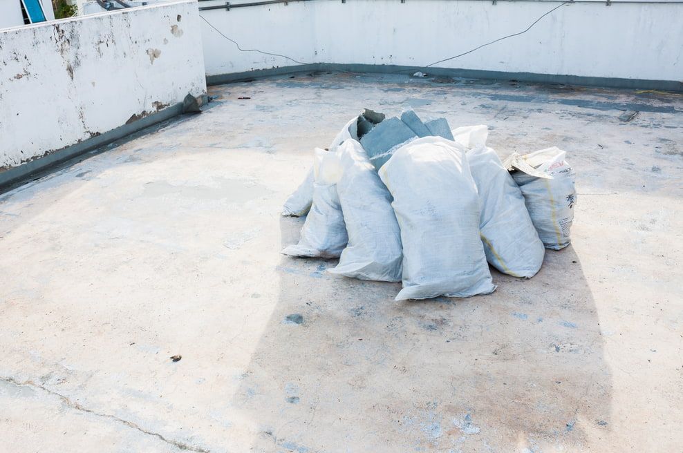 A Pile of Bags Sitting on Top of a Concrete Floor — HJK Plastering In Kyogle, NSW