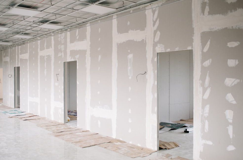 A Long Hallway With Drywall Walls and Doors in a Building — HJK Plastering In Lennox Head, NSW