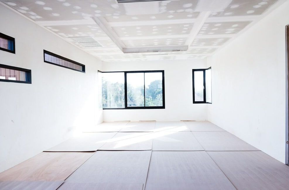 An Empty Room With a Lot of Windows and Drywall — HJK Plastering In Northern Rivers, NSW