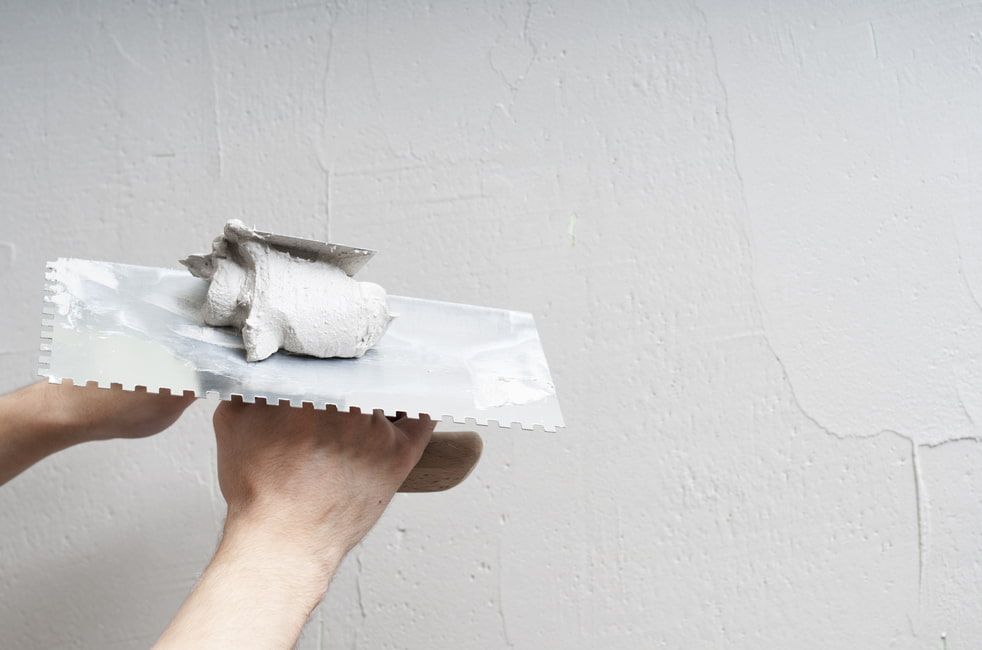 A Person is Plastering a Wall With a Trowel — HJK Plastering In Northern Rivers, NSW