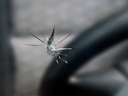 Close-up of a spider on cracked glass with a blurred gray background