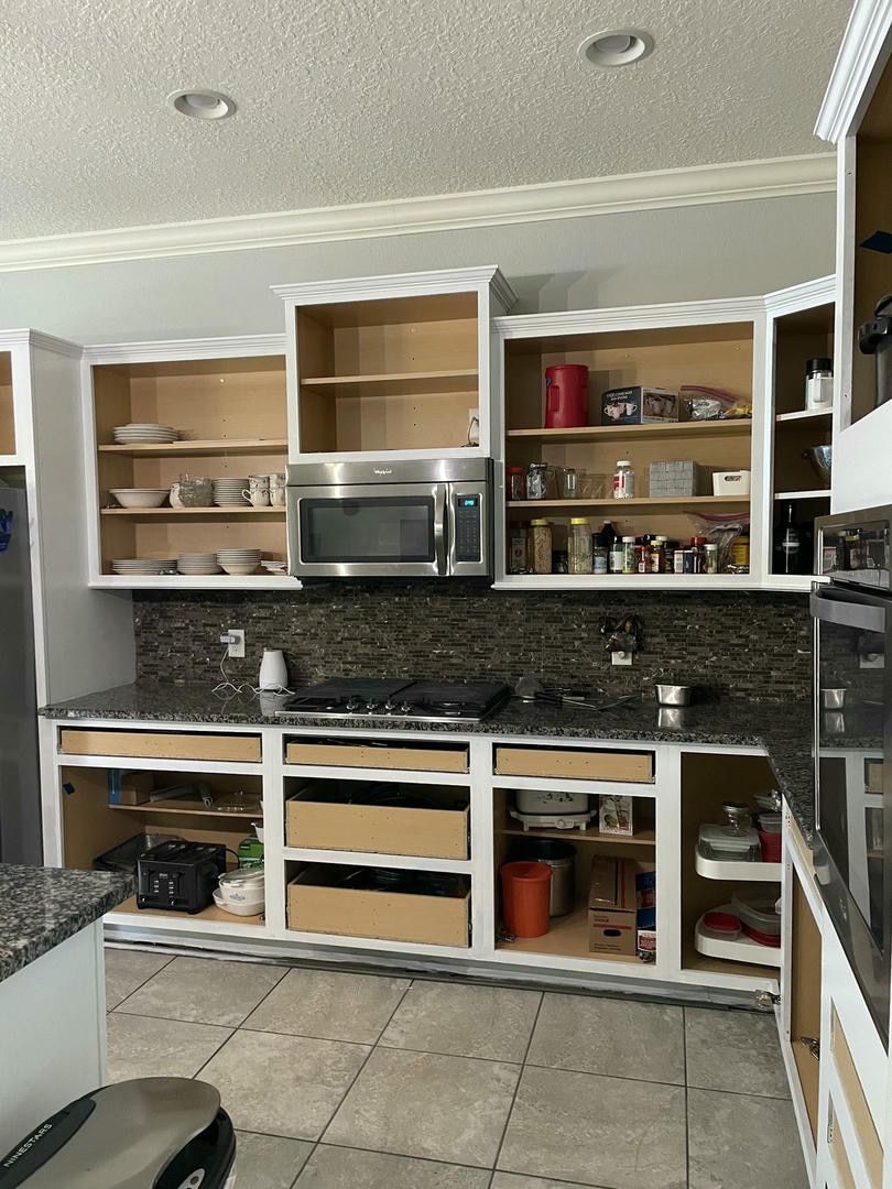 Kitchen with cabinets and appliances undergoing renovation; beige, white, and brown color scheme.