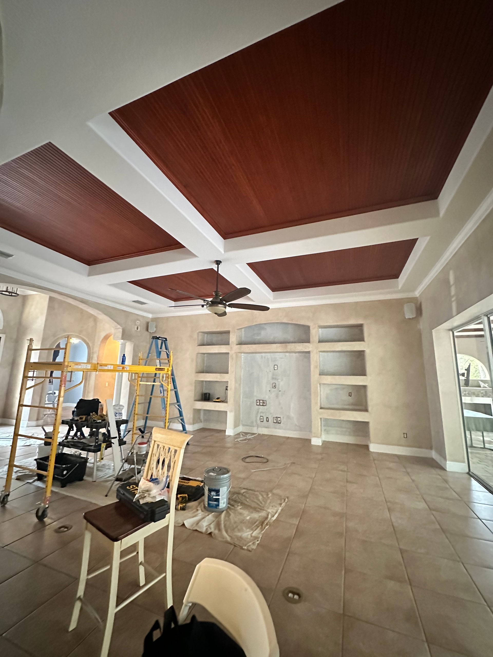 Person in protective suit painting a blue wall with a roller.