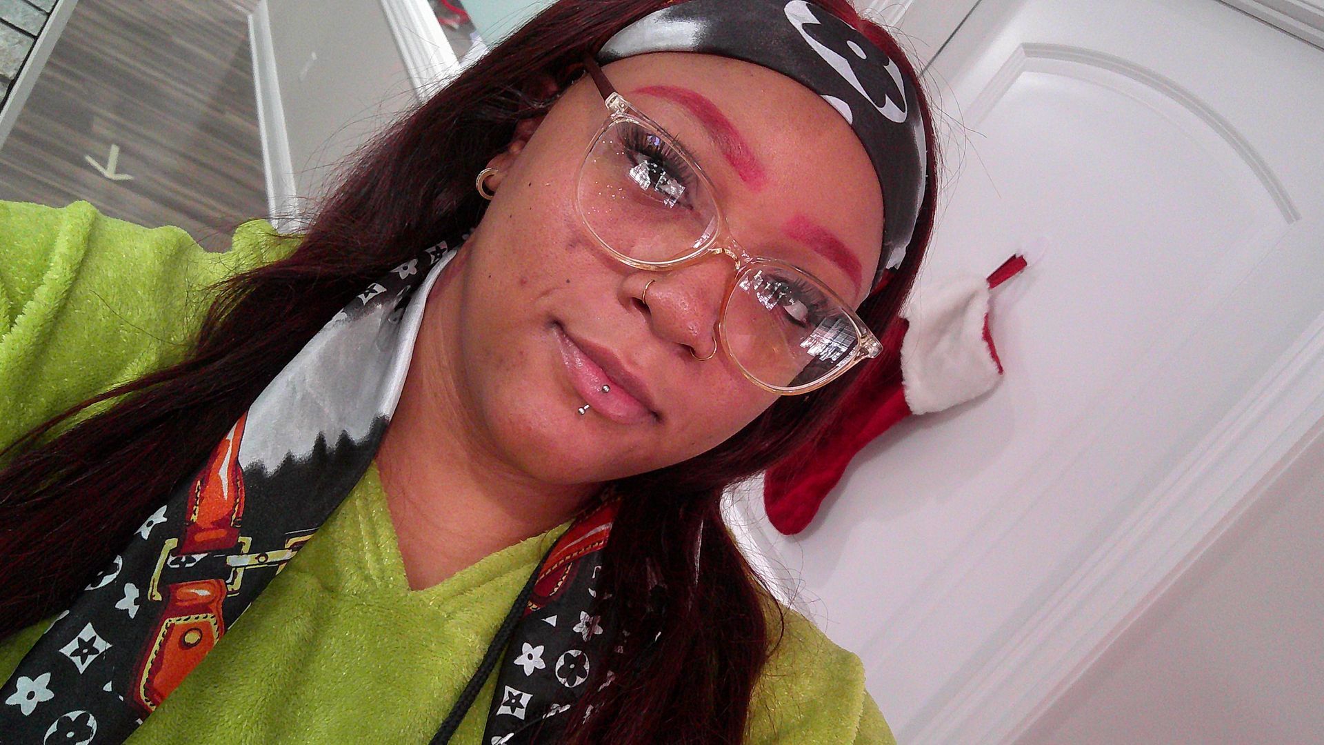 A woman is sitting at a desk with a laptop and a vase of flowers.