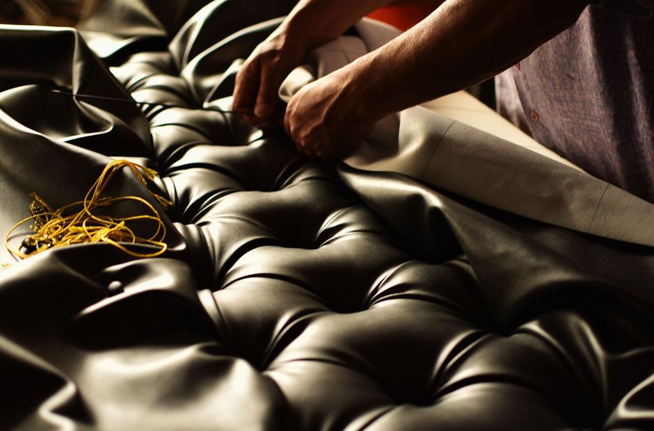 creative hands working on upholstery capitoned