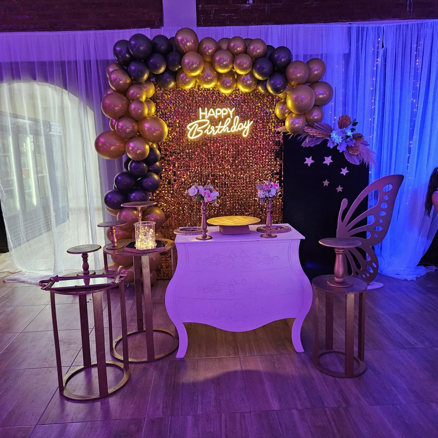 Decoración para fiesta de cumpleaños con globos, pastel y adornos. Combinación de colores dorado, negro y blanco.